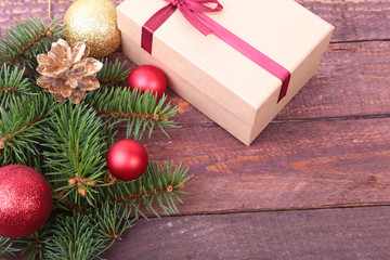 Fototapeta na wymiar Christmas fir tree with gift box and balls on wooden board