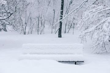 Winter mood: huge snowdrift of snow covering the bench in park at center of Kyiv, Ukraine