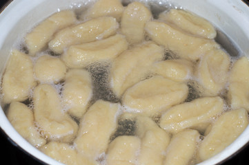 Cooking kopytka or kapytki. Polish traditional potato dumpling.