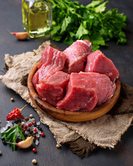 Raw chopped meat with spices on rusty background