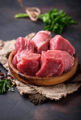 Raw chopped meat with spices on rusty background