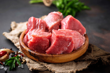 Raw chopped meat with spices on rusty background