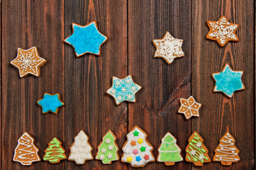 Christmas gingerbread cookies in the shape of Christmas trees on a brown wooden table. Copy space.