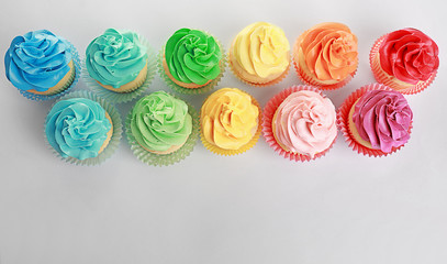 Tasty colorful cupcakes on white background