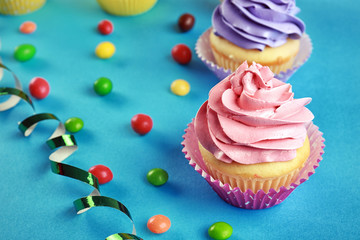 Tasty festive cupcakes on color background