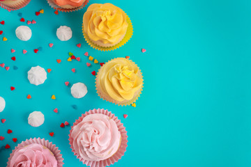 Composition with tasty cupcakes and meringues on color background