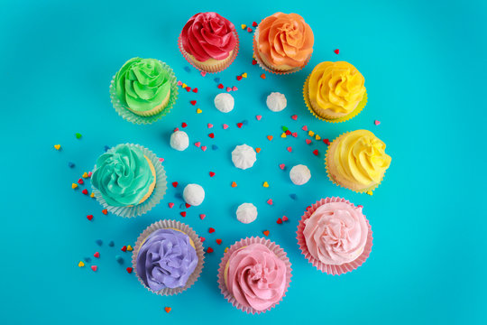 Composition with tasty cupcakes and meringues on color background