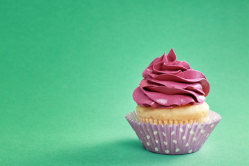Tasty cupcake on color background