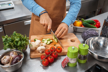 The chef in brown apron cooking in a restaurant kitchen