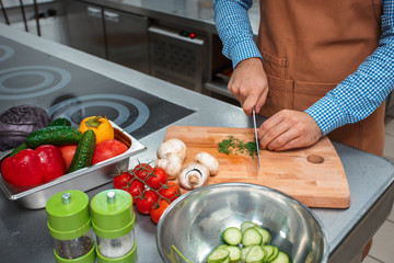 The chef in brown apron cooking in a restaurant kitchen