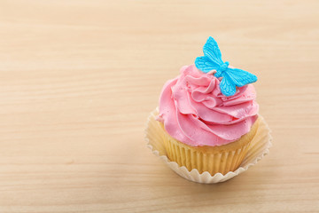 Beautiful cupcake on light wooden background