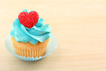 Beautiful cupcake on light wooden background