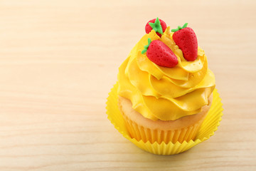 Beautiful cupcake on light wooden background