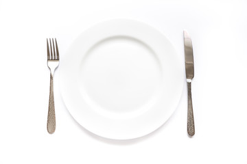 Knife, fork and plate on a white background