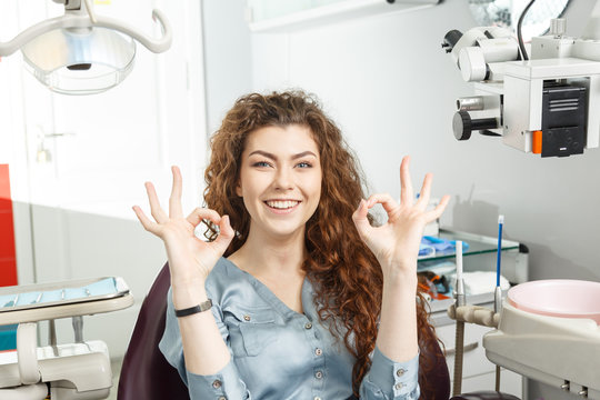 Everything is good, shows the woman signs OK. Smiling woman In a dentist's office.