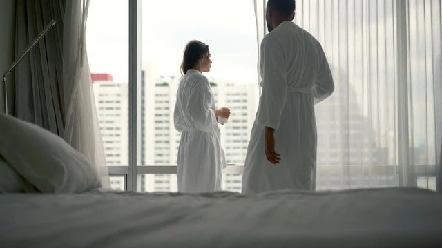 Young couple in bathrobe talking and kissing in the morning during coffee, 4K
