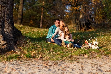 A happy family having fun in the park in autumn. Family, love, happiness concept. Family of four