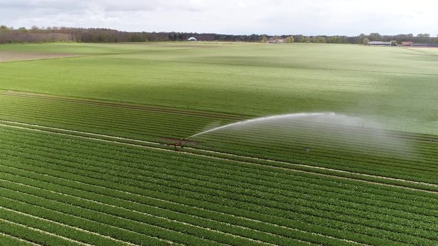 Aerial view moving towards industrial irrigation sprinkler used to irrigate agricultural crops sprinkler irrigation is method of applying irrigation water which is similar to natural rainfall 4k