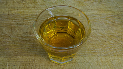 Shot Glas with schnaps on a wooden cutting board