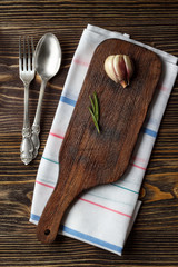 Food cooking background with wooden cutting board, cutlery and spices. Top view.