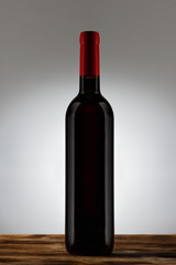 Bottle with red wine with a light gradient on the background