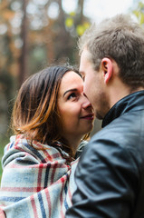 Fototapeta premium the guy with the girl walking in autumn Park. cool , snuggle under a blanket