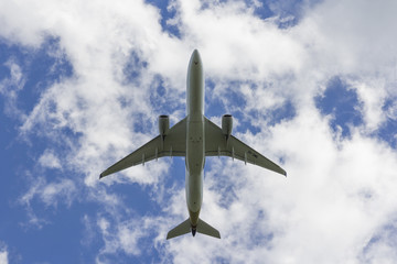 Airplane flies against a background of white cloud