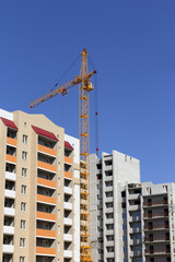 Fototapeta premium Industrial landscape, building crane against the blue sky