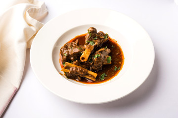 Mutton Masala Or Masala Gosht or indian lamb rogan josh with some seasoning, served with Naan or Roti, selective focus
