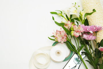 Various Flowers and Garden or Florist Tools in theCorner on warm lighten background, top view. copy Space. Pink Alstromeria and Crysanthemum.