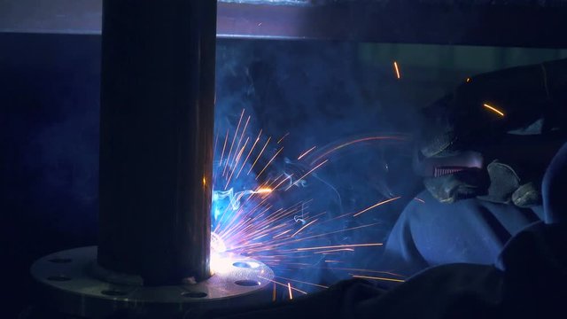 Welding work on a pipe manufacturing plant. Close up shot