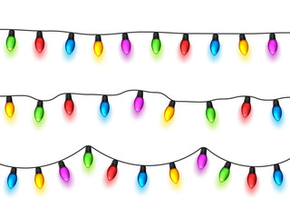 Christmas glowing lights on white background. Garlands with colored bulbs. Xmas holidays. Christmas greeting card design element. New year,winter.