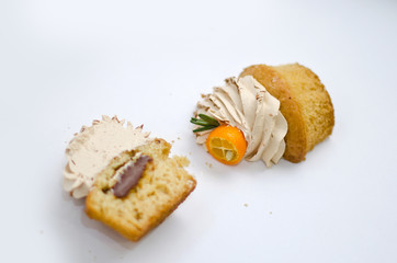 Cupcake with cumquat decoration cut in 2 pieces  isolated
