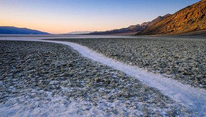 A narrow path leads off to the horizon in the salt flats of Badwater Basin, Death Valley National Park