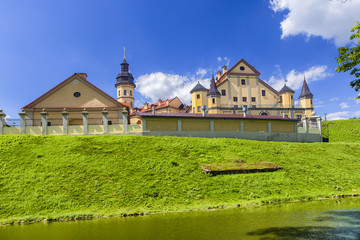 Fototapeta na wymiar Famous Tourist Destinations.Backside of Renowned Nesvizh Castle on The Moat as a Profound Example of Medieval Ages Heritage and Residence of the Radziwill Family.