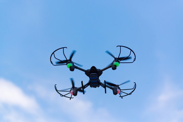 Flying drone of quad copter in blue sky.
