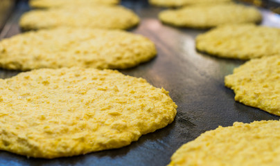Traditional Venezuelan dish cachapa, a staple corn cake, cooking at a street food market