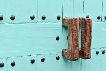 Rusty door handles on blue wooden door