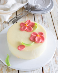 Mousse carrot orange cake with chocolate flowers on a wooden light background. Summer Flowers