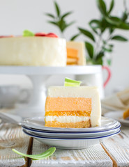 Mousse carrot orange cake with chocolate flowers on a wooden light background. Summer Flowers