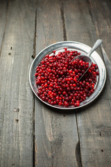 Christmas card. Frozen Red cranberries in the iron plate on a wooden background. Winter postcard. Place for your text and greetings