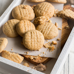 White wooden box of peanut cookies on a light white background