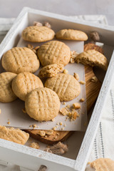 White wooden box of peanut cookies on a light white background