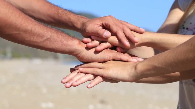 Many hands people are connected greeting together, outdoors in nature background, close up