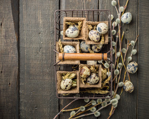 Spring Easter basket with eggs of different sizes, spring flowers, cereals, willow branches.  on a wooden dark background decorated with wheat and flowers.  Place for text. Flat lay, top view