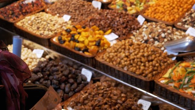 Large Counter of Dried Fruits and Nuts at a Farmers Market in La Boqueria. Barcelona. Spain. Nuts, dry fruits on display at the market on the showcase. Stall with Various dried fruits at Mercat de