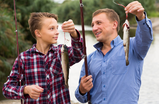 Father with son looking at fish on hook