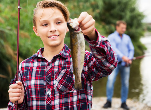 Fisher boy showing catch fish