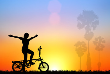 silhouette girl ride  a bicycle at sunset.
