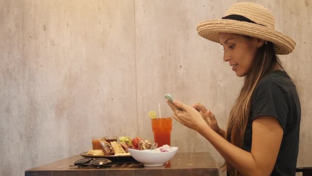Young Hipster Mixed Race Girl Taking Photo of Sweet Delicious Vegan Dessert with Smartphone in Cafe. 4K.